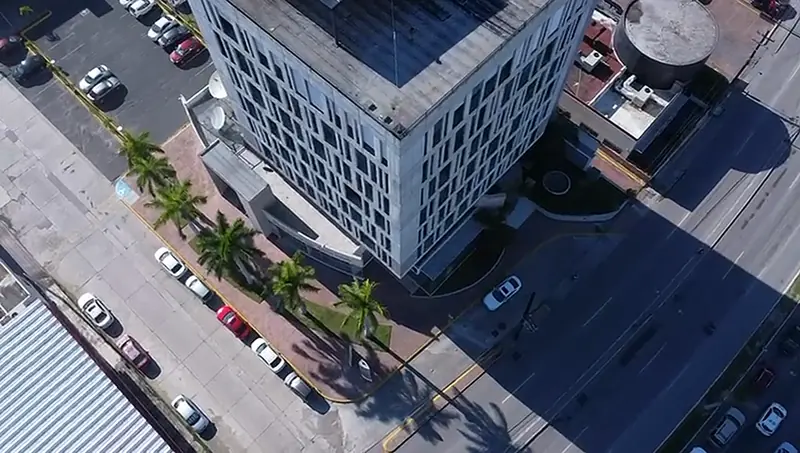 Vista cenital del edificio, la avenida y el estacionamiento