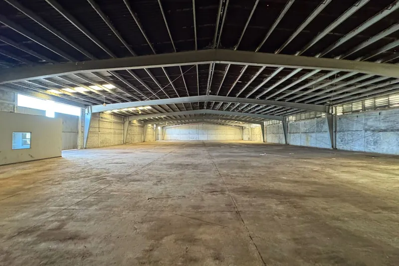Interior de la nave industrial, con estructura metálica a dos aguas y piso de concreto